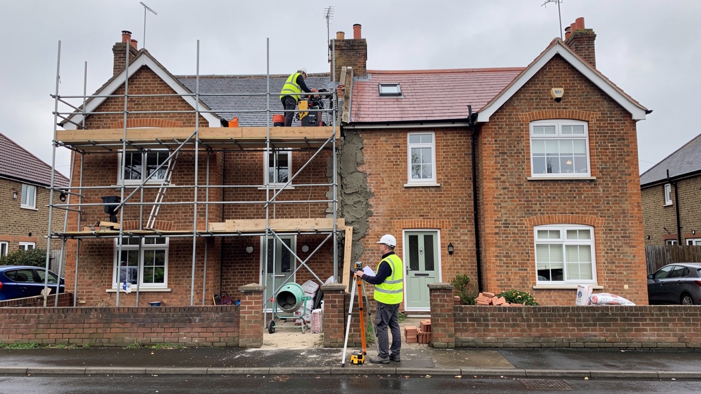 Party wall survey between two semi-detached houses with construction scaffolding